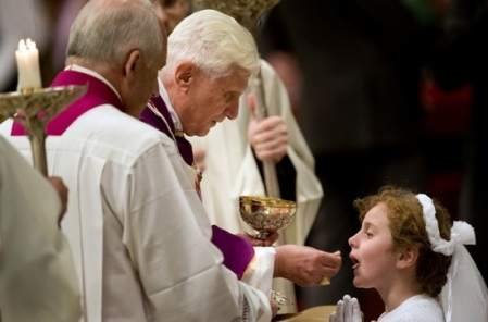 Pope Benedict distributing the Eucharist to a child